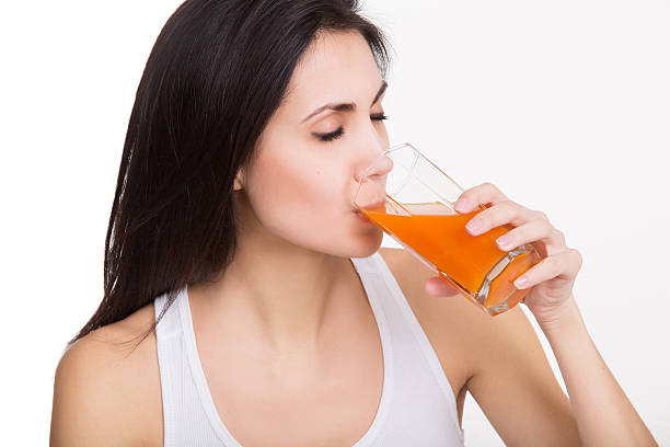 istock Pretty young woman drinking juice. Isolated 476490392