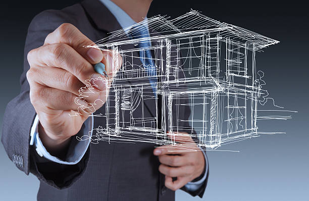 istock businessman hand drawing house in a whiteboard 476490423