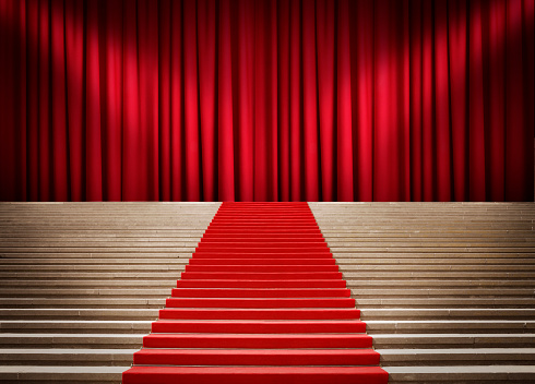 Staircase with red carpet and curtain with spotlights