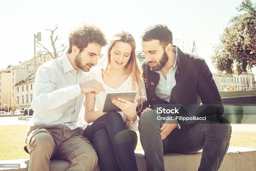 Three Friends Using Tablet Outdoor 20-24 Years Stock Photo