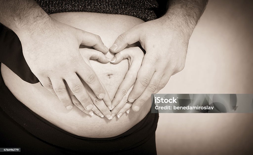 Heart Shape - Stock Image Couple Forming Heart Shape on Pregnant Belly Adult Stock Photo