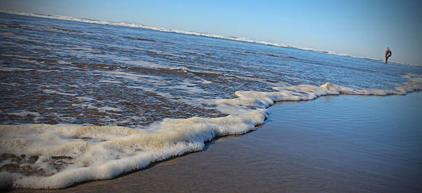 istock seashore with person in background 476498218