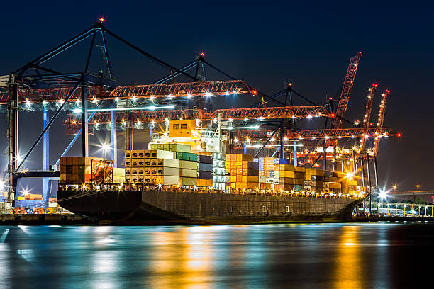 Ship loaded in New York container terminal Cargo ship loaded in New York container terminal at night viewed from Elizabeth NJ across Elizabethport reach. commercial dock stock pictures, royalty-free photos & images