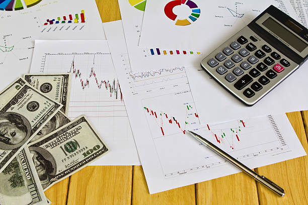 istock Pen ,calculator and dollars on financial Graphs 476504811