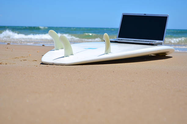 Surfing the Net A laptop on a surfboard surfboard fin stock pictures, royalty-free photos & images