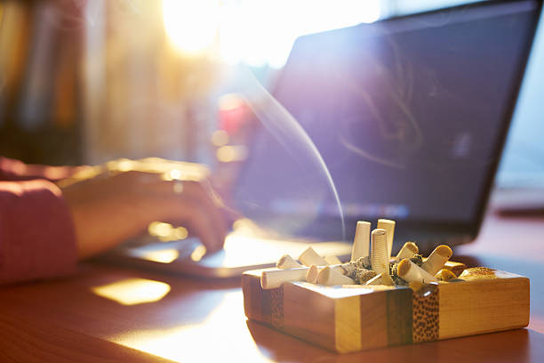 homem com laptop e fumar cigarro de manhã - nicotine healthcare and medicine smoking issues lifestyles imagens e fotografias de stock