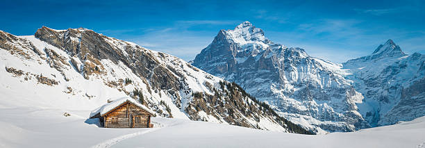chalet de montagne idyllique de neige dans les montagnes d'hiver alpes panorama de la suisse - snow european alps house grindelwald photos et images de collection