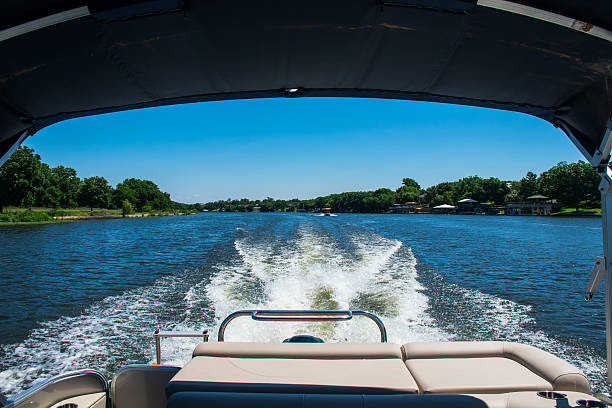 Dream Looking Back at Wake Driving on Lake Travis Dream Looking Back at Wake Driving on Lake Travis or Lake LBJ. looking back out the back of the boat , Wake of waves of water expanding from the middle of the lake , shade from the canape outside of Austin ,Texas . Driving on the colorado river in Central texas.  pontoon boat stock pictures, royalty-free photos & images