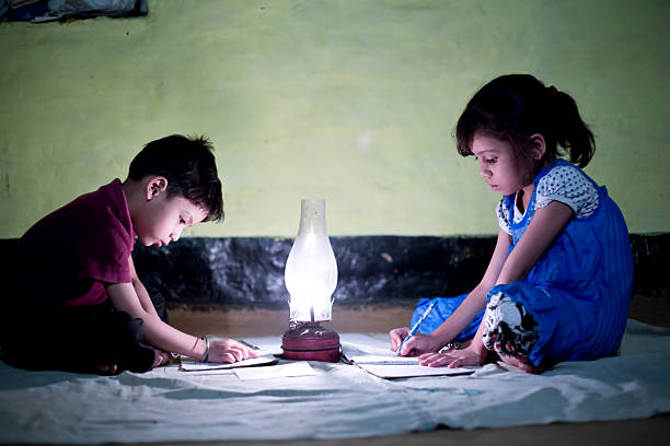 Village Girl and boy studying in lighting lamp