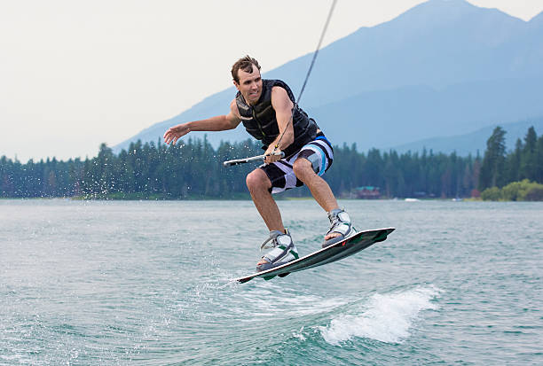 człowiek uprawiania wakeboardingu na pięknym mountain lake - wakeboarding motorboating extreme sports waterskiing zdjęcia i obrazy z banku zdjęć