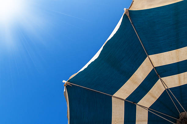 istock sun umbrella in blue sky with sunny shine 476520018