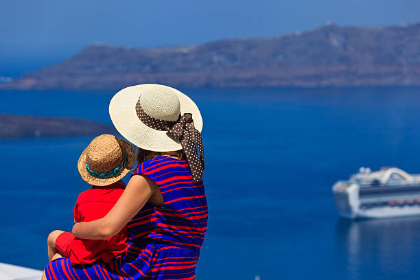 istock family looking at Santorini, Greece 476525331