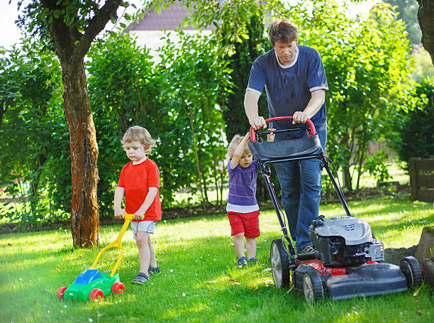 istock Man and two sibling boys having fun with lawn mower 476529381