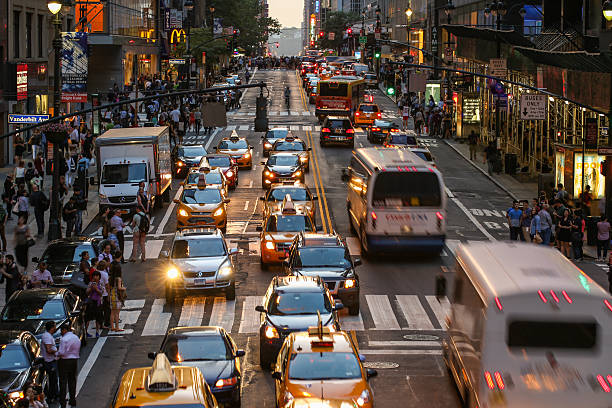 Commuters crossing 42nd Street in New York City, USA Commuters crossing busy 42nd Street in New York City, USA in afternoon. Vast number of people and vehicles hit the streets and avenues of Manhattan every day. 42nd street photos stock pictures, royalty-free photos & images