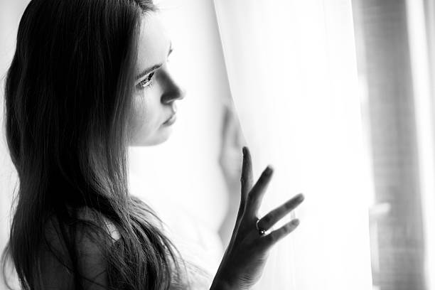 istock Beautiful Woman Looking Through Window 476538686