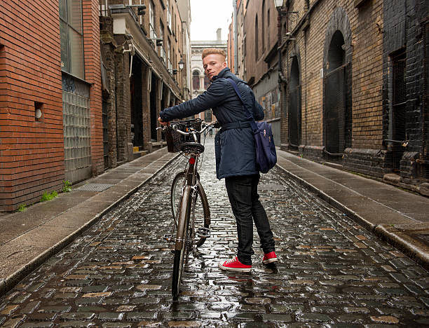 istock Red haired man walking in the city with his bicycle. 476539244