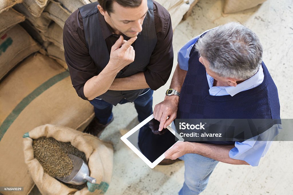 Top view of small business owners Two business partners working at a coffee storage roomhttp://www.vela-photo.com/istock/banner_coffee.jpg Adult Stock Photo