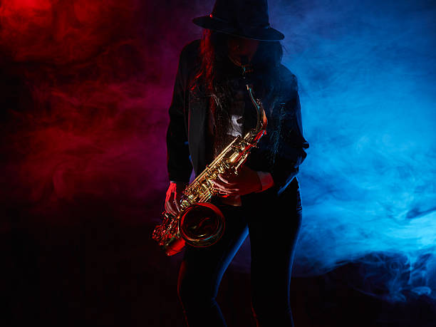 istock Beautiful young woman plays saxophone 476545918