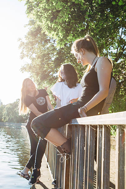 istock young women sitting on a railing, 476547186