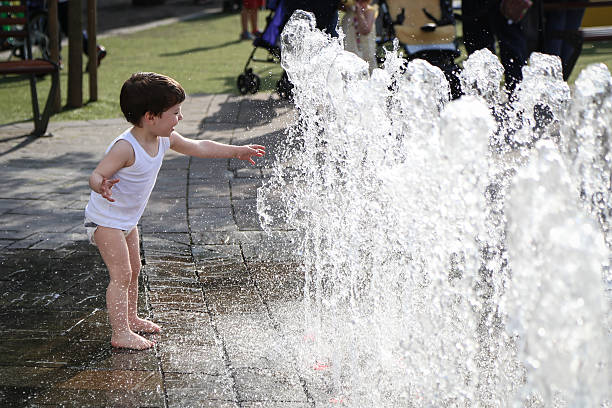 istock Little boy playing with the fountain 476549238