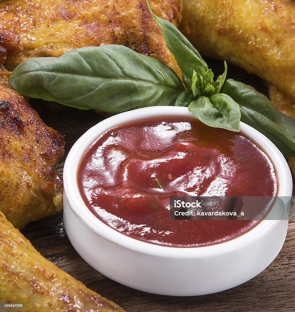 red sauce in background of fried chicken red sauce in gravy boat against the background of fried chicken and spinach Red Wine Sauce Stock Photo