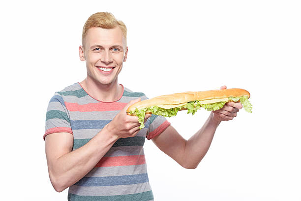 istock Smiling man standing with long loaf sandwich 476553718