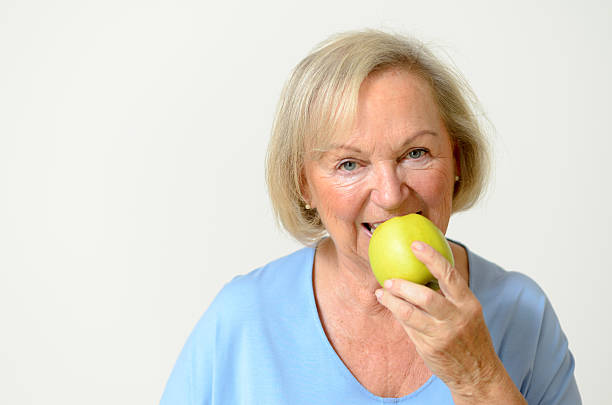 istock Happy healthy senior lady with a green apple 476554504
