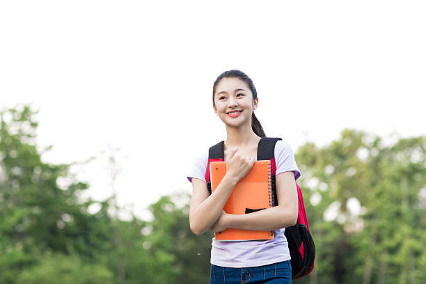 istock asian female student with backpack and notebooks smiling 476558902