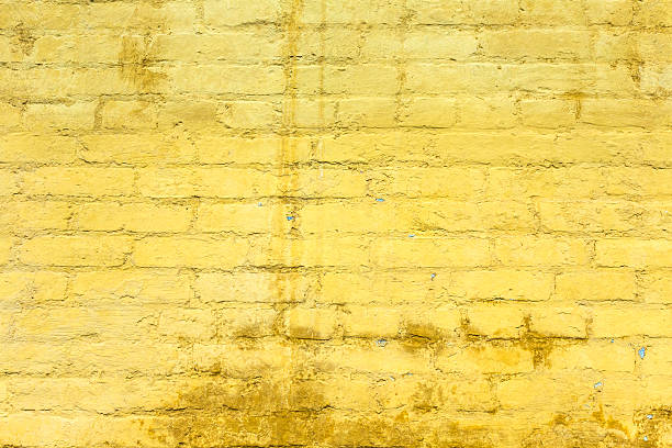 amarillo pintado vieja pared de ladrillos - retro revival old fashioned old architecture fotografías e imágenes de stock