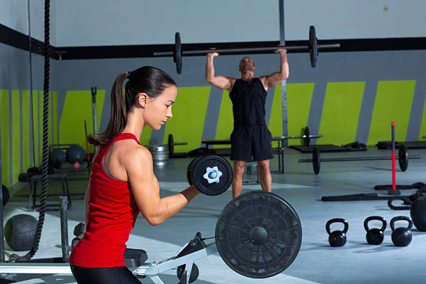 istock girl dumbbell and man weight lifting bar workout 476563631