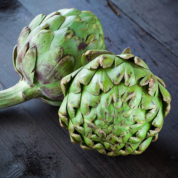 istock Fresh green artichokes on wooden table 476563860