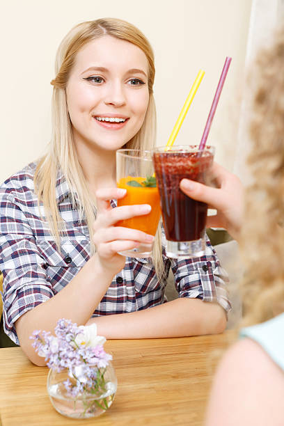 istock Two women clinking glasses with cocktails in cafe 476563976