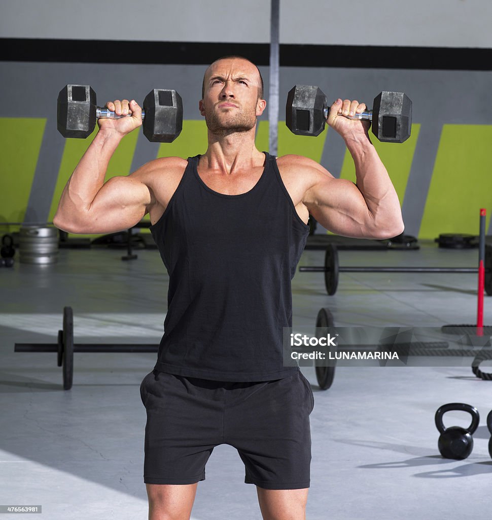 Gym man with dumbbells exercise gym Gym man with dumbbells weights lifting exercise gym fitness workout 20-29 Years Stock Photo