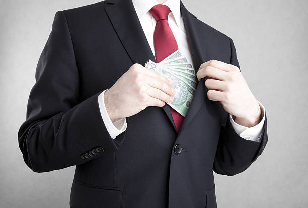 istock Corruption. Man putting polish money in suit jacket pocket. 476564156