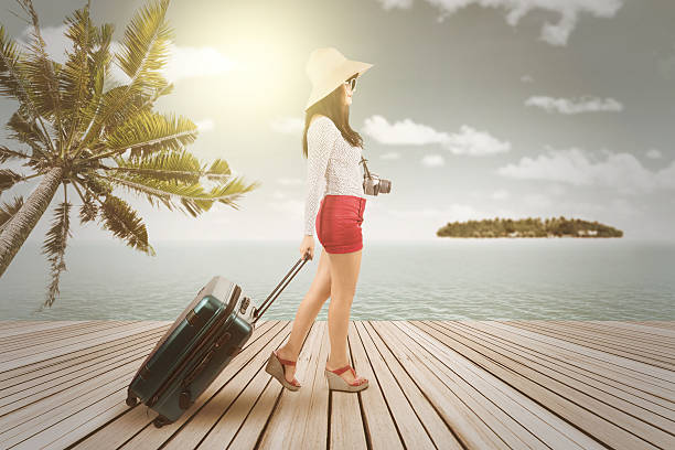 istock Happy woman with suitcase at pier 476564302