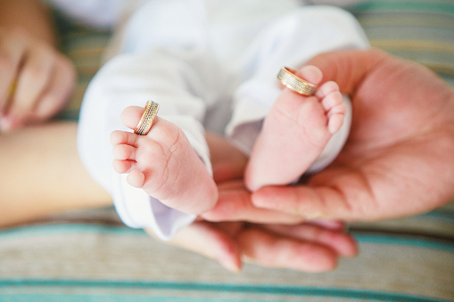 Newborn toes with wedding rings around the big toes.