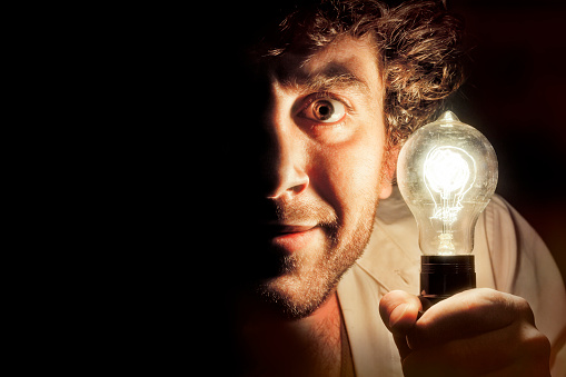 Decorative antique edison style filament light bulb coming out of man's mouth