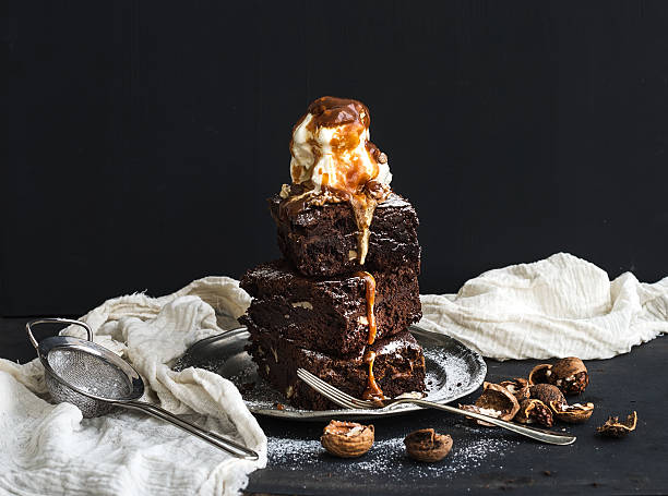 úmido torre de brownies com caramelo salgado, nozes e sorvete - baked ice - fotografias e filmes do acervo