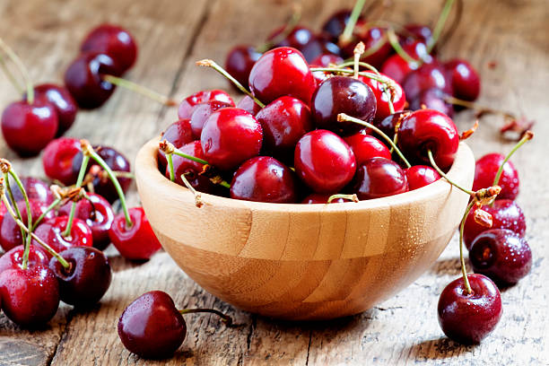 istock Fresh cherries in a wooden bowl, selective focus 476568936