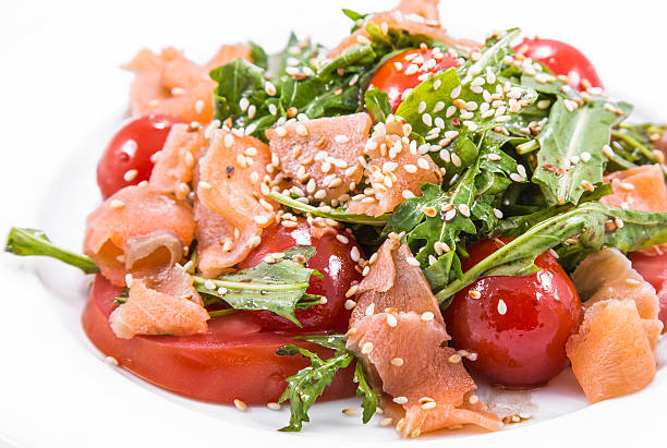 salad of red fish with tomato and sesame salad of red fish with fresh tomato and sesame on white background salmon and red snapper stock pictures, royalty-free photos & images