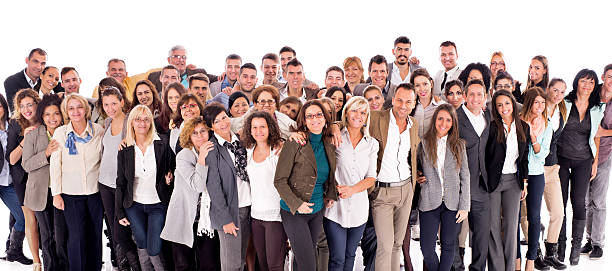 Large group of happy embraced business people isolated on white. Crowd of happy business people standing embraced and looking at the camera. Isolated on white. large group of people facing camera stock pictures, royalty-free photos & images
