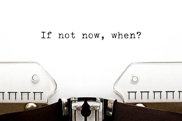 Typewriter If Not Now When Concept image with If Not Now, When printed on an old typewriter. important message stock pictures, royalty-free photos & images