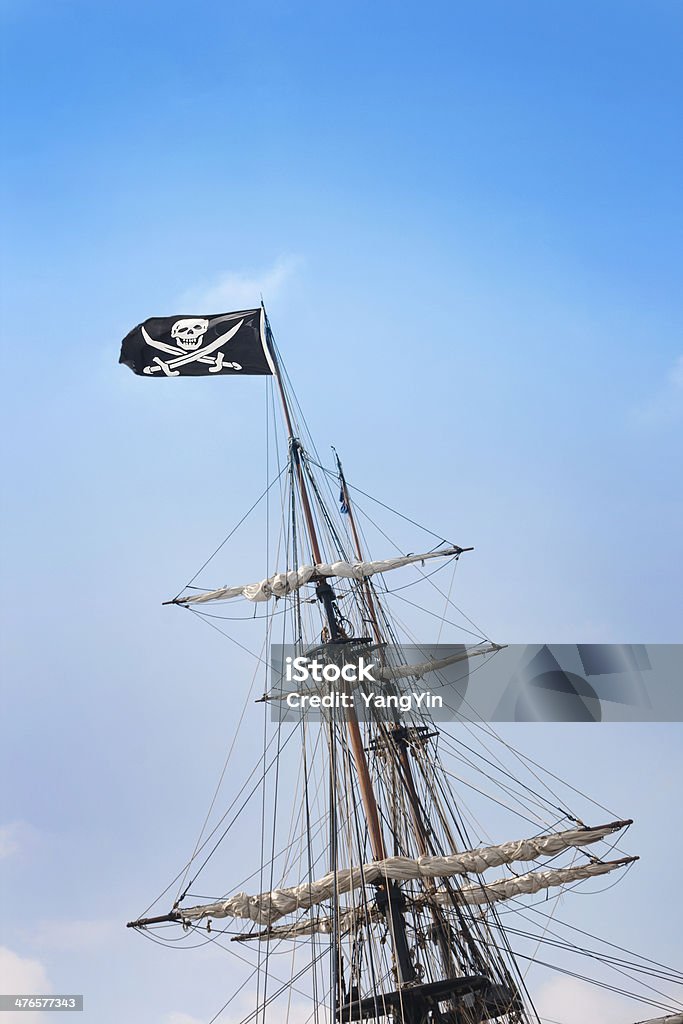 Jolly Roger caveira e ossos cruzados bandeira com mastro de um navio pirata - Foto de stock de Cor Preta royalty-free