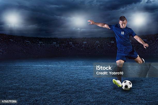 Soccer Player Kicking Ball In A Large Stadium At Night Stock Photo - Download Image Now