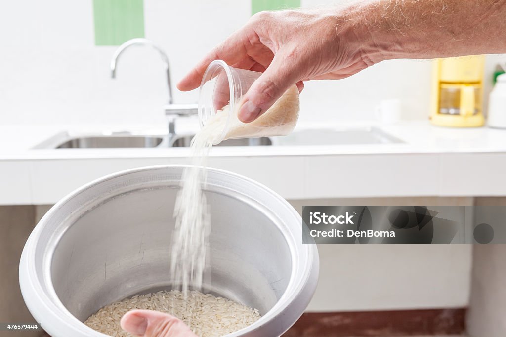 measuring cup measuring cup with rice that I pour in the rice cooker Rice Cooker Stock Photo