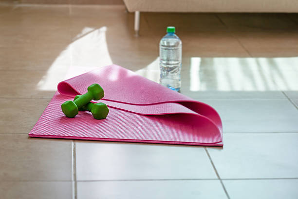 istock Two  dumbbells with mineral water on  yoga mat 476581164
