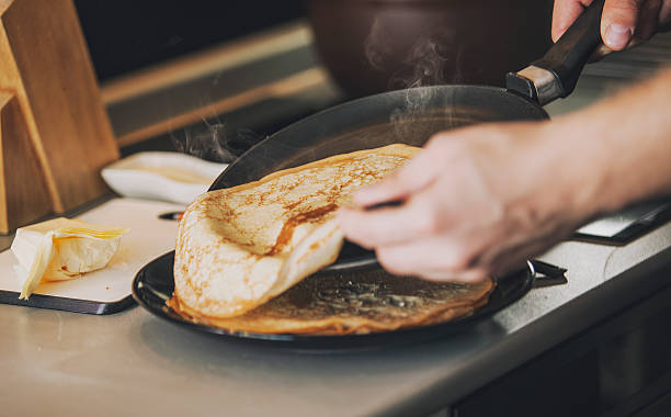 il processo di cottura frittelle su una casseruola con lungo manico - terra cotta pot foto e immagini stock