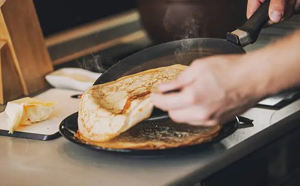 Photo of The process of cooking pancakes on a skillet