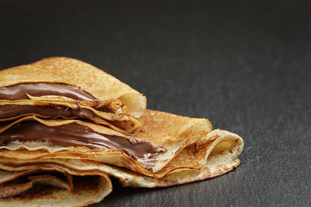 istock thin crepes or blinis with chocolate cream on slate 476583590