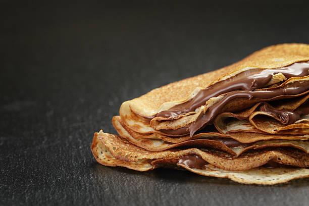 istock thin crepes or blinis with chocolate cream on slate 476583604